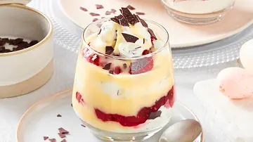 Im Glas werden weiße Quarkcreme, Himbeerkonfitüre und Eierlikör geschichtet. Garniert wird das Glas mit Eierlikörtraum mit Schokoraspel. Das Glas steht auf einen Teller, auf dem außerdem ein Dessertlöffel liegt. Im Hintergrund sind ein weiteres Glas und hellrosa Eier zu erkennen. - Foto: LECKER @ Bauer Media Group Im Glas werden weiße Quarkcreme, Himbeerkonfitüre und Eierlikör geschichtet. Garniert wird das Glas mit Eierlikörtraum mit Schokoraspel. Das Glas steht auf einen Teller, auf dem außerdem ein Dessertlöffel liegt. Im Hintergrund sind ein weiteres Glas und hellrosa Eier zu erkennen. - Foto: LECKER @ Bauer Media Group