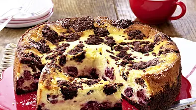 Eierlikör-Zupfkuchen aus der Springform, auf einer roten Kuchenplatte, mit Puderzucker bestäubt - Foto: LECKER @ Bauer Media Group