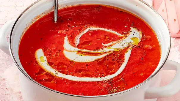 Ein großer weißer Topf mit leuchtend roter Tomatensuppe und Sahneswirl. - Foto: LECKER @ Bauer Media Group Ein großer weißer Topf mit leuchtend roter Tomatensuppe und Sahneswirl. - Foto: LECKER @ Bauer Media Group