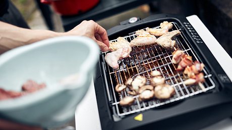 Fleisch und Spieße auf einem Elektrogrill im Freien - Foto: iStock/m-gucci