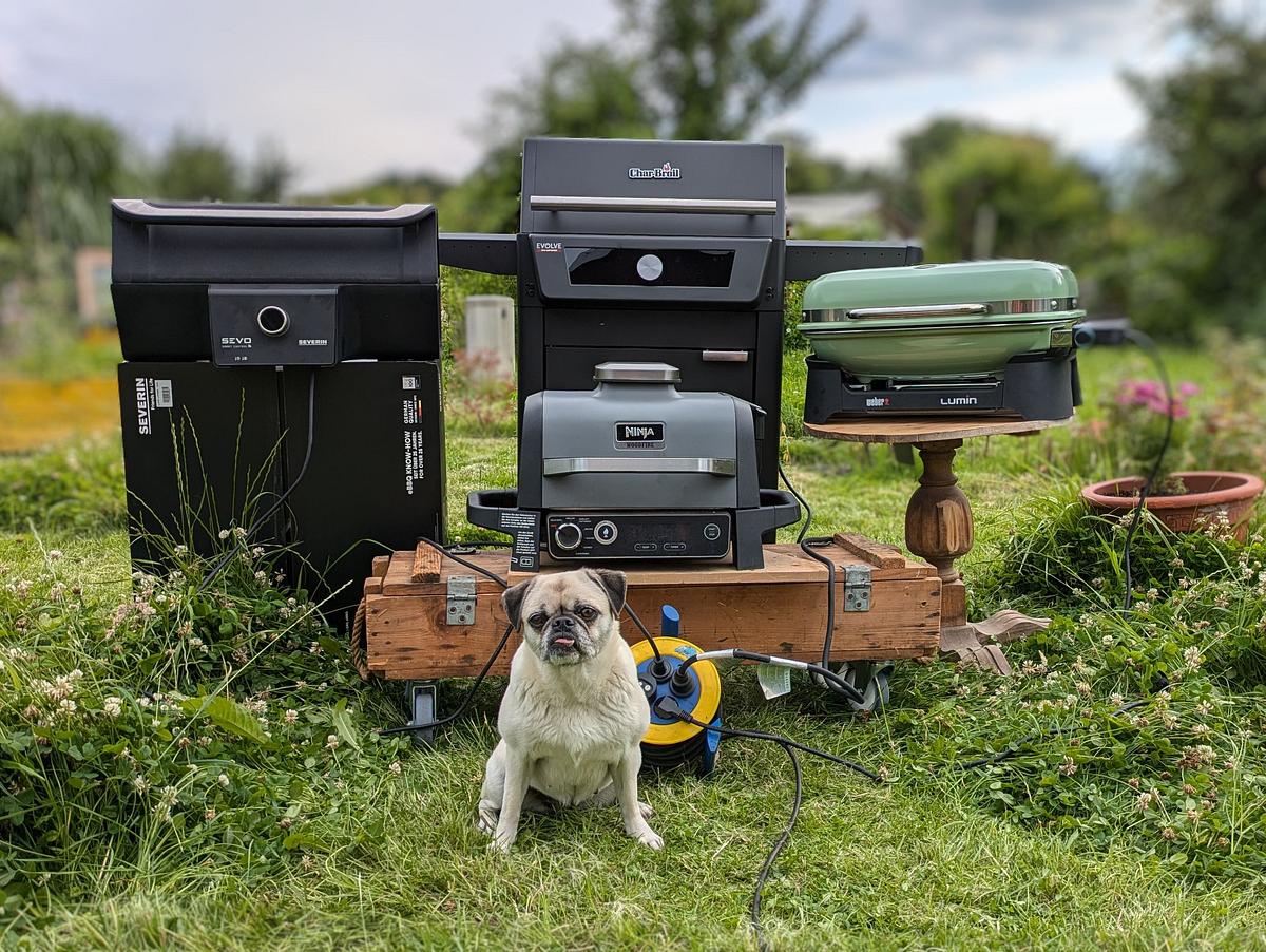 Vier Elektrogrills im Garten mit Mops davor