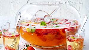 Erdbeerbowle in einem Bowle-Gefäß mit Schöpflöffel, daneben 3 Gläser mit Bowle und kleinen Gabeln - Foto: House of Food / Bauer Food Experts KG