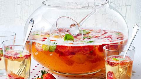 Erdbeerbowle in einem Bowle-Gefäß mit Schöpflöffel, daneben 3 Gläser mit Bowle und kleinen Gabeln - Foto: House of Food / Bauer Food Experts KG