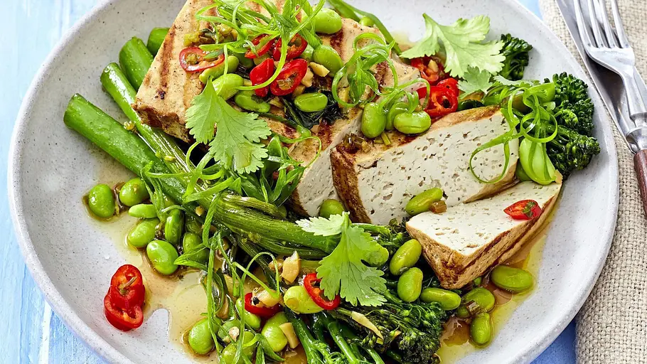 Gegrillte Tofuscheiben auf einem Bett aus grünem Gemüse wie Brokkolini, Edamame und grünen Bohnen, garniert mit frischen Kräutern und Chiliringe. - Foto: LECKER @ Bauer Media Group Gegrillte Tofuscheiben auf einem Bett aus grünem Gemüse wie Brokkolini, Edamame und grünen Bohnen, garniert mit frischen Kräutern und Chiliringe. - Foto: LECKER @ Bauer Media Group