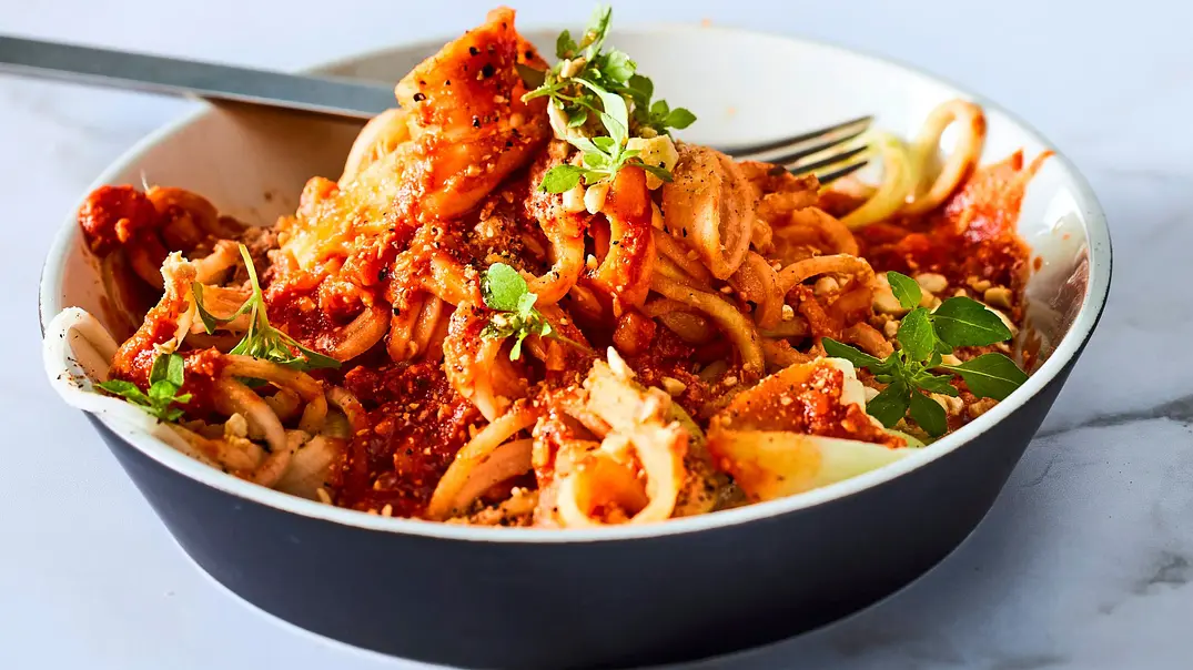 Kohlrabi-Zoodles mit herzhafter Bolognese-Sauce und frischen Kräutern, in einer tiefen Schale serviert und mit etwas Käse bestreut. - Foto: LECKER @ Bauer Media Group