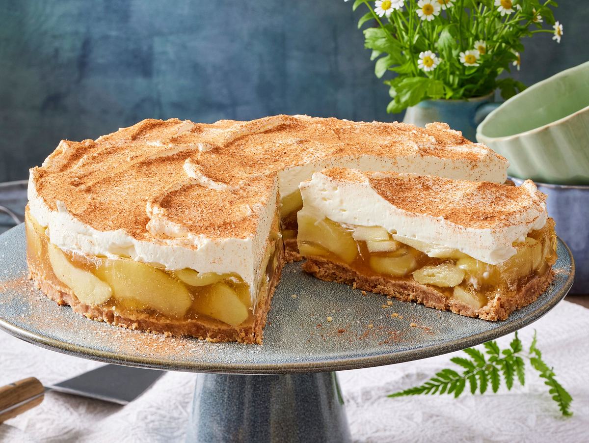 Cantuccini-Apfelkuchen ohne Backen in einer Runden Form, mit einer Weißen Creme getopped und mit Zimt bestreut