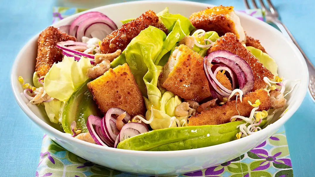 Knusprige Fischstäbchenstücke auf einem frischen Blattsalat mit roten Zwiebelringen und Sprossen, angerichtet in einer weißen Schüssel auf einem bunt gemusterten Stoffserviette. - Foto: LECKER @ Bauer Media Group Knusprige Fischstäbchenstücke auf einem frischen Blattsalat mit roten Zwiebelringen und Sprossen, angerichtet in einer weißen Schüssel auf einem bunt gemusterten Stoffserviette. - Foto: LECKER @ Bauer Media Group
