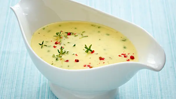 Weiße Sauciere gefüllt mit cremiger Schweizer Käsesoße, verfeinert mit geschmolzenem Käse und einer hellen, samtigen Textur. - Foto: LECKER @ Bauer Media Group
