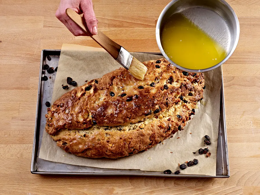 Christstollen Rezept: Stollen direkt nach dem Backen mit Butter bepinseln Christstollen Rezept: Stollen direkt nach dem Backen mit Butter bepinseln