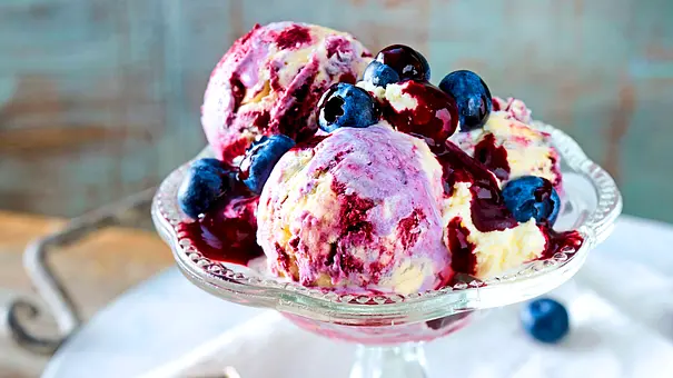 Cremiges Blaubeereis in einer Eisschale aus Glas mit frischen Blaubeeren oben drauf. - Foto: LECKER @ Bauer Media Group Cremiges Blaubeereis in einer Eisschale aus Glas mit frischen Blaubeeren oben drauf. - Foto: LECKER @ Bauer Media Group