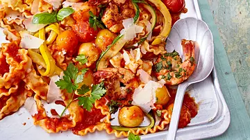 Mafaldine-Nudeln mit gebratenen Garnelen, bunten Cherrytomaten, Zucchinistreifen, frischen Kräutern und Parmesanspänen auf einem silbernen Backblech angerichtet. - Foto: LECKER @ Bauer Media Group Mafaldine-Nudeln mit gebratenen Garnelen, bunten Cherrytomaten, Zucchinistreifen, frischen Kräutern und Parmesanspänen auf einem silbernen Backblech angerichtet. - Foto: LECKER @ Bauer Media Group
