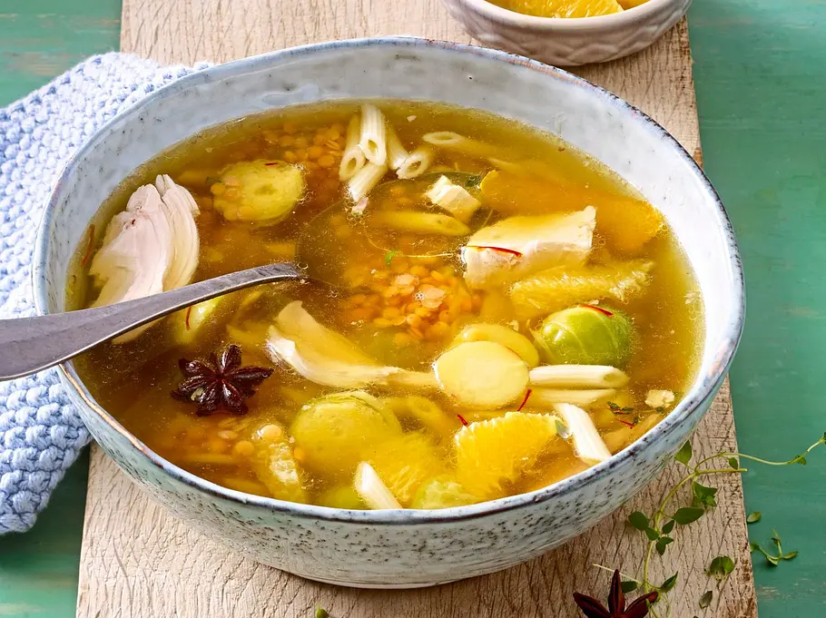 Hähnchen-Orangen-Suppe mit Stückchen in einer Schüssel Hähnchen-Orangen-Suppe mit Stückchen in einer Schüssel