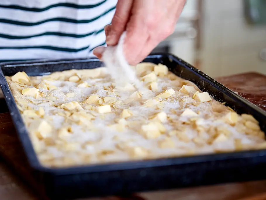 Zuckerkuchen: Hefeteig mit Zucker bestreuen Zuckerkuchen: Hefeteig mit Zucker bestreuen