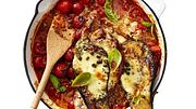 Überbackene Schnitzel-Auberginen in Doppeldecker-Optik auf Tomatensugo mit frischen Kirschtomaten und Basilikum, serviert in einer Auflaufform. - Foto: LECKER @ Bauer Media Group
