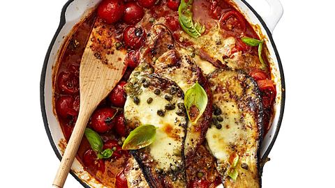 Überbackene Schnitzel-Auberginen in Doppeldecker-Optik auf Tomatensugo mit frischen Kirschtomaten und Basilikum, serviert in einer Auflaufform. - Foto: LECKER @ Bauer Media Group