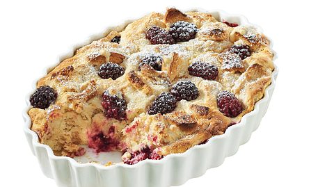 Süßer Quarkauflauf mit Brombeeren und Puderzucker in einer weißen Auflaufform. - Foto: LECKER @ Bauer Media Group