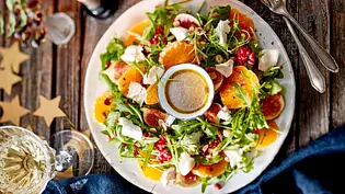 Clementinensalat mit Feigen und Ziegenkäse auf einem großen Teller, in der Mitte ein Schälchen mit Dressing - Foto: LECKER @ Bauer Media Group