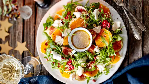 Clementinensalat mit Feigen und Ziegenkäse auf einem großen Teller, in der Mitte ein Schälchen mit Dressing - Foto: LECKER @ Bauer Media Group
