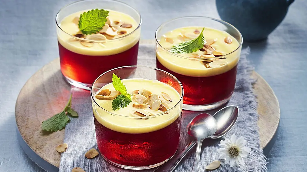 Rote Götterspeise in Gläsern, bedeckt mit cremiger Vanillesoße, bestreut mit gehobelten Mandeln und garniert mit einem frischen Minzblatt. - Foto: LECKER @ Bauer Media Group Rote Götterspeise in Gläsern, bedeckt mit cremiger Vanillesoße, bestreut mit gehobelten Mandeln und garniert mit einem frischen Minzblatt. - Foto: LECKER @ Bauer Media Group
