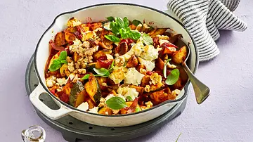 Bunte Zucchini-Champignon-Pfanne mit gebratenem Gemüse, Feta, frischen Kräutern und Walnüssen in einer weißen Pfanne auf einer hellen Unterlage, dazu eine kleine Holzplatte mit Nüssen und grüner Deko. - Foto: LECKER @ Bauer Media Group Bunte Zucchini-Champignon-Pfanne mit gebratenem Gemüse, Feta, frischen Kräutern und Walnüssen in einer weißen Pfanne auf einer hellen Unterlage, dazu eine kleine Holzplatte mit Nüssen und grüner Deko. - Foto: LECKER @ Bauer Media Group
