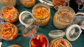 Auf einem Tisch mit grüner Oberfläche stehen verschiedene geöffnete Bügelgläser mit Fermenten - Foto: LECKER @ Bauer Media Group / Katharina Klieme