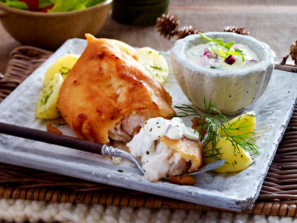 Fisch im Bierteig auf einem Teller mit Kartoffeln und Remoulade