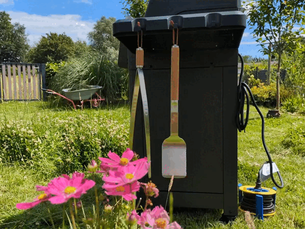Fiskars Norden Grillbesteck Set baumelt an einem Elektrogrill.