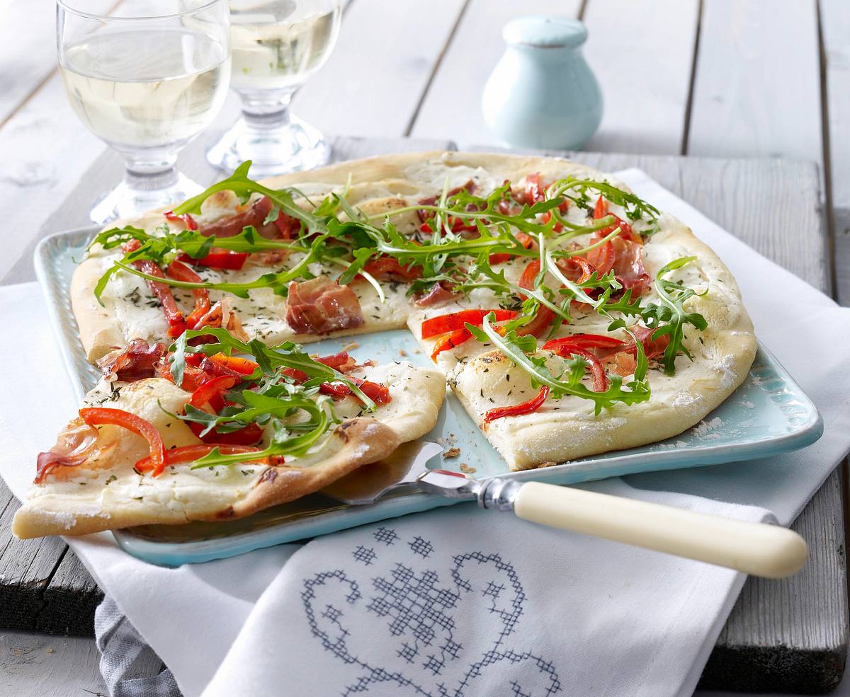 Flammkuchen mit Ziegenfrischkäse, Parmaschinken und Rucola Rezept