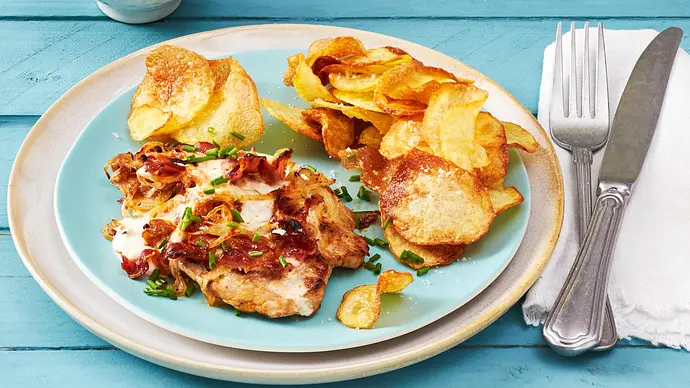 Flammkuchen Schnitzel aus dem Airfryer auf einem hellblauen Teller. Daneben eine weiße Serviette, auf der Besteck liegt. - Foto: LECKER @ Bauer Media Group Flammkuchen Schnitzel aus dem Airfryer auf einem hellblauen Teller. Daneben eine weiße Serviette, auf der Besteck liegt. - Foto: LECKER @ Bauer Media Group