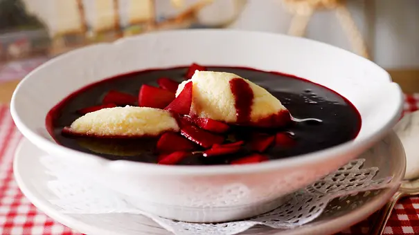 Fliederbeersuppe mit Grießklößchen und Apfel in einem tiefen Teller serviert. - Foto: LECKER @ Bauer Media Group