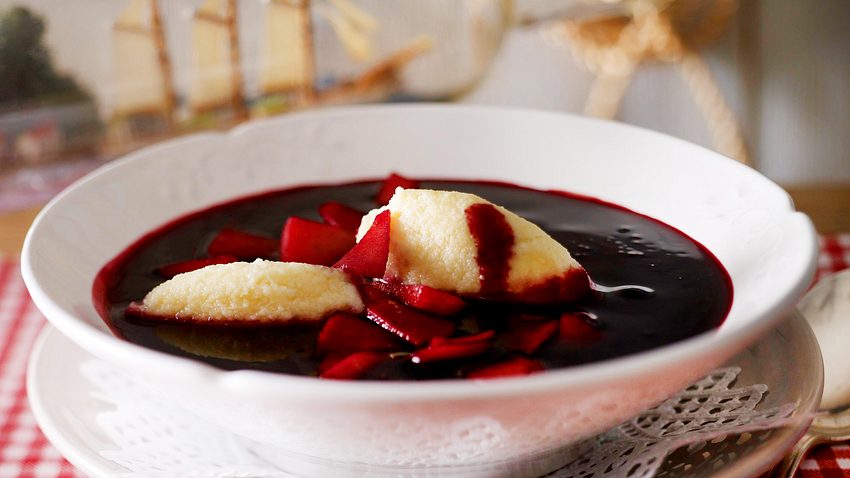 Fliederbeersuppe mit Grießklößchen und Apfel in einem tiefen Teller serviert. - Foto: LECKER @ Bauer Media Group