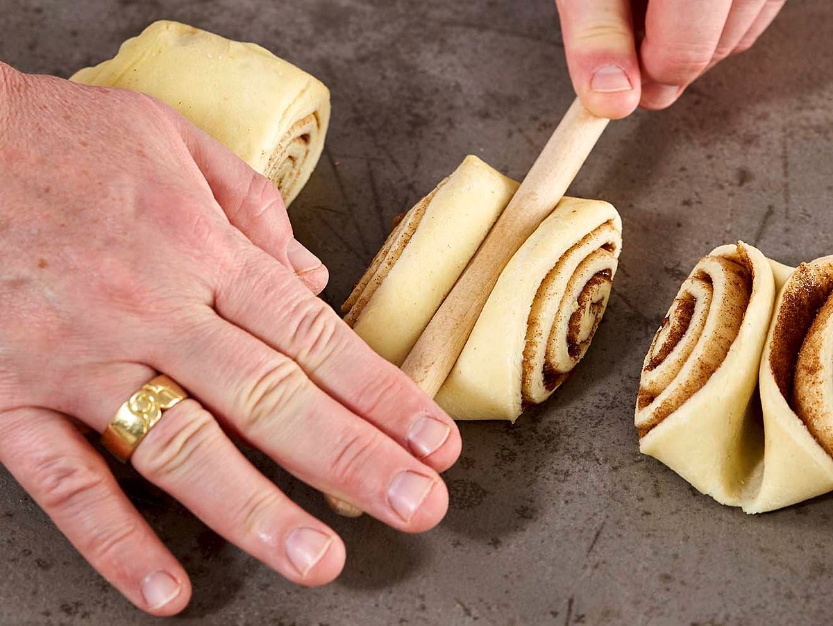 Franzbrötchen mit einem Kochlöffelstiel formen