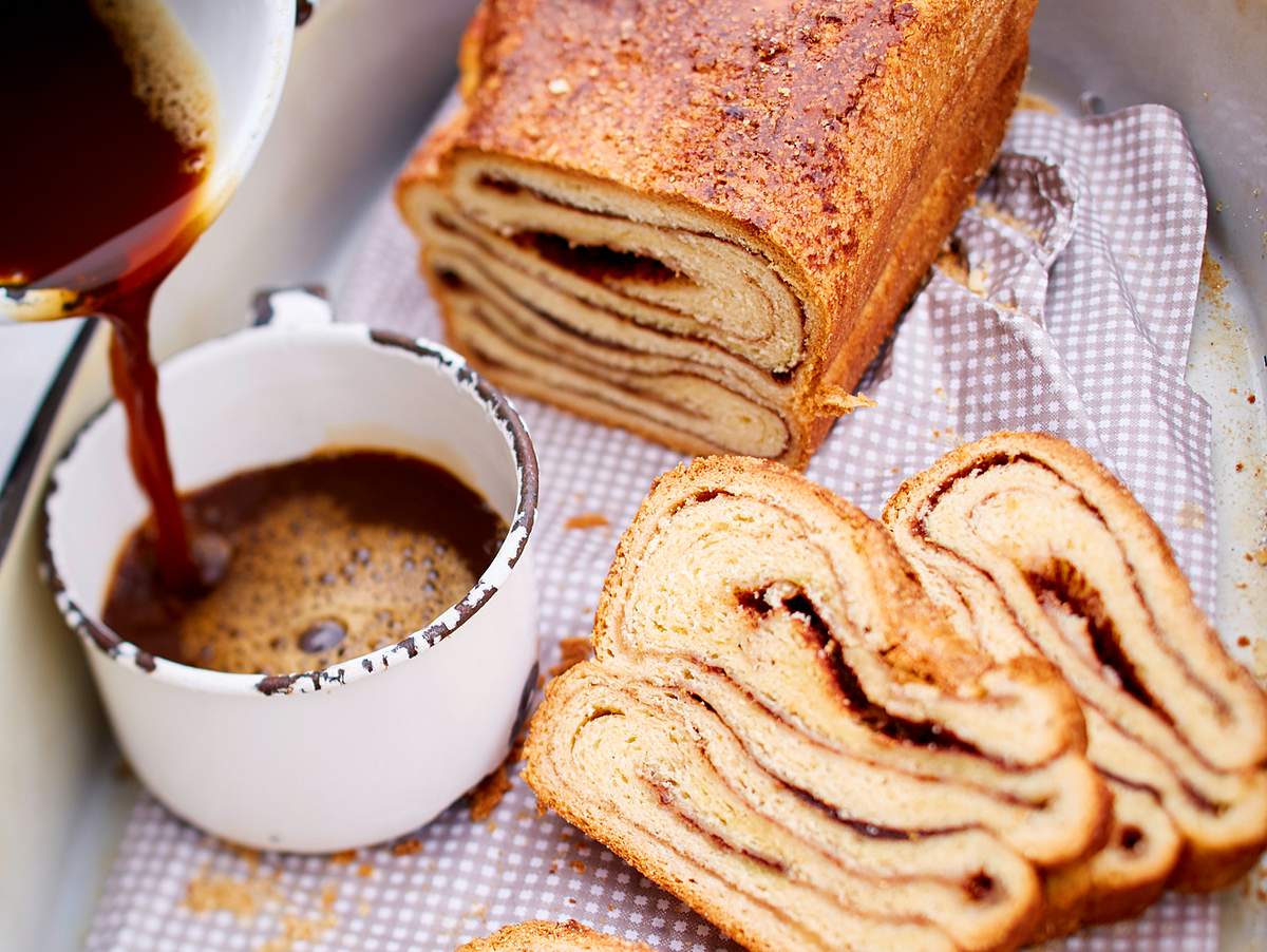 Franzbrötchenkuchen: angeschnittener Hefekuchen mit Kaffee