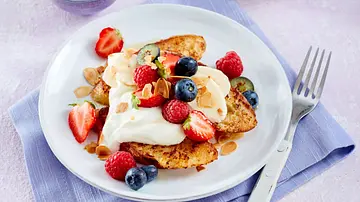 Drei goldbraune gebratene French Toast auf einem weißen Teller mit Quarkcreme, frischen Beeren und Mandelblättchen, daneben eine Gabel. - Foto: LECKER @ Bauer Media Group Drei goldbraune gebratene French Toast auf einem weißen Teller mit Quarkcreme, frischen Beeren und Mandelblättchen, daneben eine Gabel. - Foto: LECKER @ Bauer Media Group