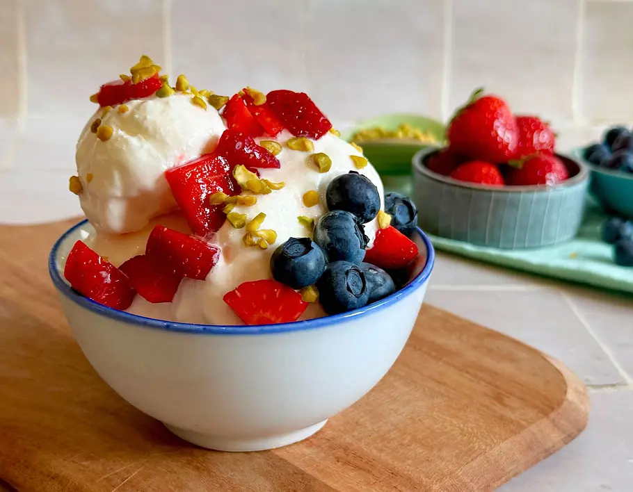 Frozen Joghurt in einer Schale garniert mit Erdbeeren, Heidelbeeren und Pistazie