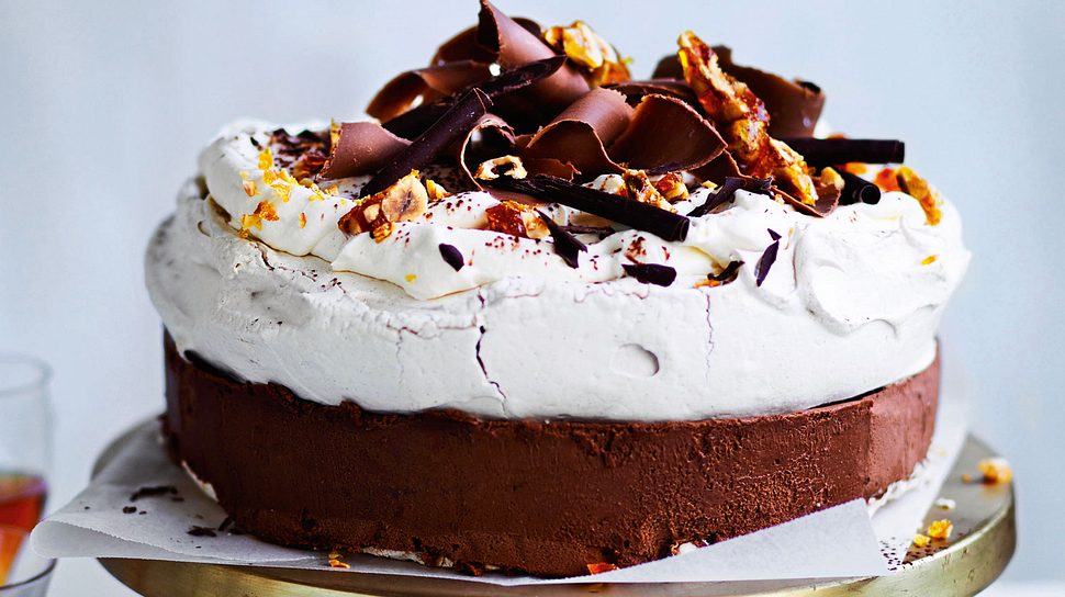 Schokoladige Frozen Pavlova Torte mit Schokospäne auf einem goldenen Tortenständer - Foto: House of Food / Bauer Food Experts KG