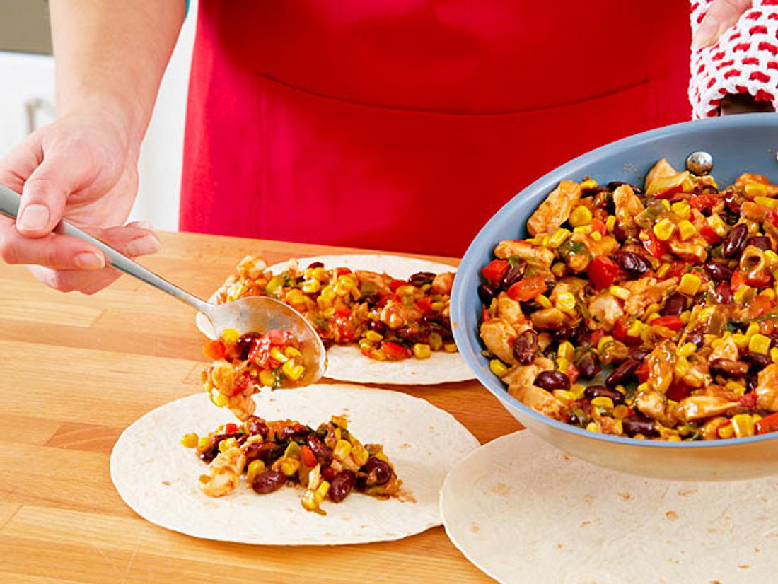 Die Füllung der Enchiladas gleichmäßig verteilen