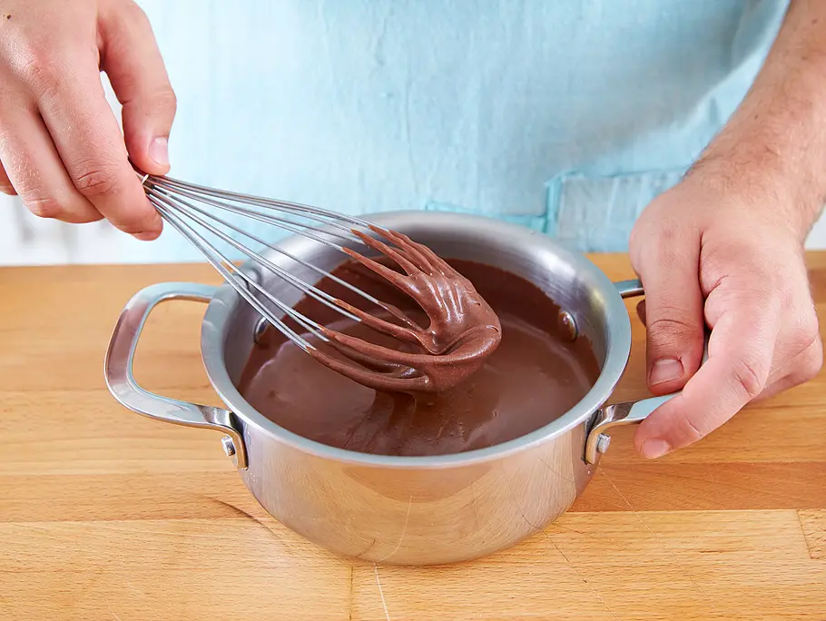 Ganache: Schokolade unter Rühren in der Sahne schmelzen Ganache: Schokolade unter Rühren in der Sahne schmelzen