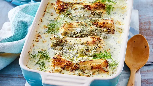 Seelachs mit Dill-Rahmsoße in einer hellblauen Auflaufform, daneben ein Holzlöffel - Foto: LECKER @ Bauer Media Group Seelachs mit Dill-Rahmsoße in einer hellblauen Auflaufform, daneben ein Holzlöffel - Foto: LECKER @ Bauer Media Group