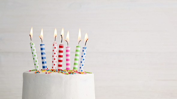 Bunte Geburtstagskerzen auf Torte mit Konfetti - Foto: iStock/kirin_photo