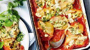 Gefüllte Muschelnudeln mit Tomatensoße in der Auflaufform mit Servierlöffel und ein angerichteter Teller mit grünem Salat  - Foto: House of Food / Bauer Food Experts KG