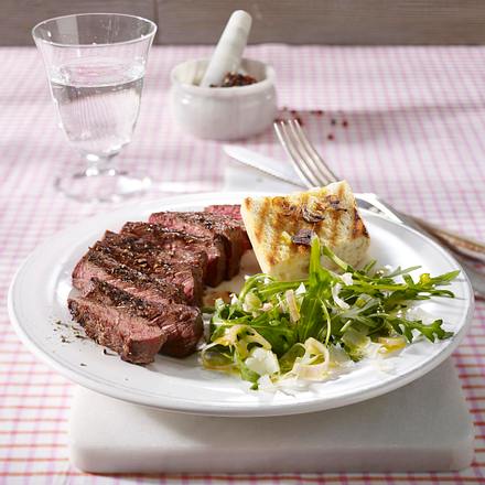Gegrilltes Rumpsteak auf Rucola-Salat mit feinen Parmesanspänen und Knoblauch-Baguette Rezept Gegrilltes Rumpsteak auf Rucola-Salat mit feinen Parmesanspänen und Knoblauch-Baguette Rezept