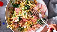 Spätzle-Salat mit Radieschenscheiben, Gurke, Spinat und Schinken in cremigem Joghurt-Dressing, serviert in einer Schüssel mit Gabel. - Foto: LECKER @ Bauer Media Group
