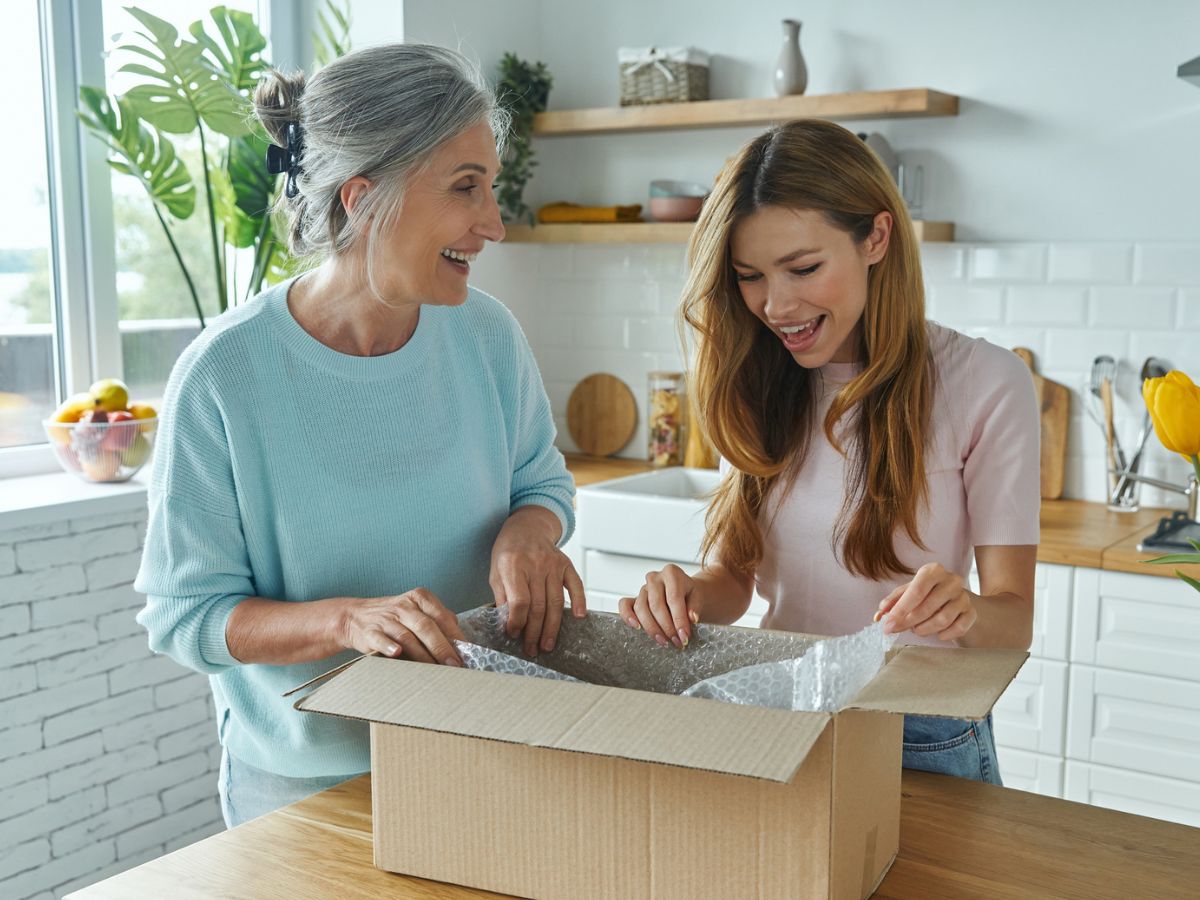 Mutter und Tochter packen Paket aus