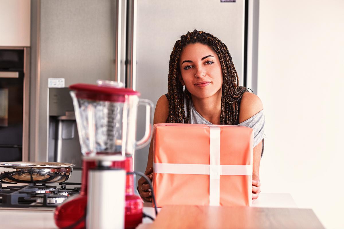 Studentin mit Geschenk in ihrer Küche