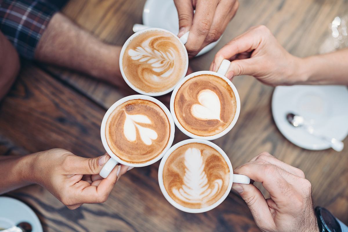 Geschenke für Kaffeeliebhaber: Kaffeetassen stoßen zusammen