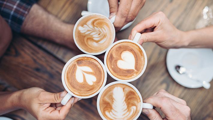 Geschenke für Kaffeeliebhaber: Kaffeetassen stoßen zusammen - Foto: istock/pixelfit