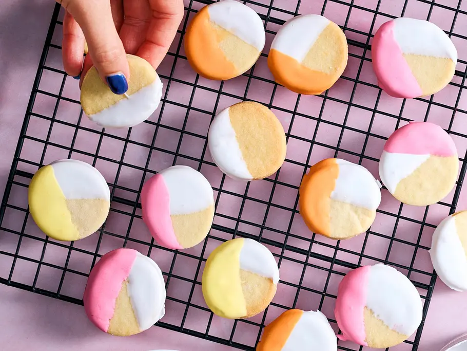 Getunkte Pastell-Plätzchen Getunkte, geometrisch verzierte Plätzchen in Pastell auf einem Abkühlgitter.