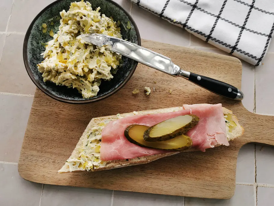 Gewürzgurkenbutter auf einem belegte Baguette mit Kochschinken und Gewürzgurkenscheiben