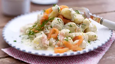 Auf einem Teller liegen Gnocchi in einer Dill-Soße mit Streifen auf Räucherlachs und Dill als Garnitur - Foto: LECKER @ Bauer Media Group